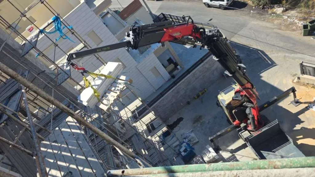 מנוף מניף מטען אל גג בניין בבנייה, מבט מהאוויר